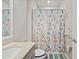 Bright bathroom featuring a gray vanity, neutral countertop, and a decorative floral shower curtain at 10303 Malvasia Ave, Riverview, FL 33578