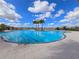A sparkling community pool on a sunny day, complete with palm trees, tiling, and lounge seating at 10303 Malvasia Ave, Riverview, FL 33578