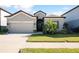 Charming single-story home with a well-manicured lawn and a two-car garage on a sunny day at 10303 Malvasia Ave, Riverview, FL 33578