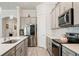 Well-equipped kitchen with stainless steel appliances, gray cabinetry, quartz countertops and tile floors at 10303 Malvasia Ave, Riverview, FL 33578