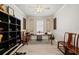 A home office featuring stylish, gray wood-look floors, elegant furniture, and serene lighting at 10303 Malvasia Ave, Riverview, FL 33578