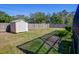 View of the backyard with a storage shed and a spacious green lawn at 10833 96Th N St, Largo, FL 33773