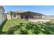 A backyard features green lawn, a screened-in patio and white fence at 11506 Mansfield Point Dr, Riverview, FL 33569