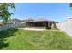 Expansive backyard featuring a screened patio, lush green lawn, and privacy fence at 11506 Mansfield Point Dr, Riverview, FL 33569