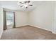 Spacious bedroom featuring a ceiling fan, a window, and neutral carpeting at 11506 Mansfield Point Dr, Riverview, FL 33569