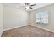 Bright bedroom featuring a ceiling fan, a window, and neutral carpeting at 11506 Mansfield Point Dr, Riverview, FL 33569