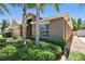 Inviting home featuring a lush lawn, mature trees, and a two-car garage at 11506 Mansfield Point Dr, Riverview, FL 33569