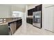 Modern kitchen featuring stainless steel appliances, dark cabinetry, and tiled floors at 11506 Mansfield Point Dr, Riverview, FL 33569