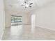 Open living room with tile floors, a ceiling fan, and access to the screened porch through sliding glass doors at 11506 Mansfield Point Dr, Riverview, FL 33569