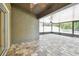 This is a screened-in patio with stone flooring and a ceiling fan at 11506 Mansfield Point Dr, Riverview, FL 33569
