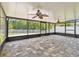 Spacious screened-in patio features fan, tile flooring and view of landscaped yard at 11506 Mansfield Point Dr, Riverview, FL 33569