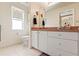Bright bathroom features a tiled floor, white vanity, and ample natural light at 11800 Ivywood Pl, New Port Richey, FL 34654