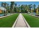 Outdoor bocce ball court surrounded by benches and green lawns lined with trees at 11800 Ivywood Pl, New Port Richey, FL 34654