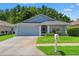 Charming single-story home featuring a well-manicured lawn, two-car garage, and lovely landscaping at 11800 Ivywood Pl, New Port Richey, FL 34654
