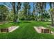 Outdoor horseshoe pit located in a grassy area with shade trees and benches at 11800 Ivywood Pl, New Port Richey, FL 34654