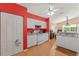 Bright kitchen with white cabinets, a ceiling fan, and view of the dining room at 11800 Ivywood Pl, New Port Richey, FL 34654
