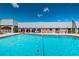 Large community pool with clear blue water and surrounding deck area with lounge chairs and umbrellas at 11800 Ivywood Pl, New Port Richey, FL 34654