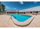 Clean and inviting community pool with a spacious brick deck and comfortable seating areas at 11800 Ivywood Pl, New Port Richey, FL 34654