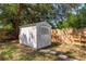 Backyard shot featuring a white storage shed with a wood fence under a large shade tree at 1253 Union St, Clearwater, FL 33755
