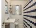 Bathroom featuring a sink with shuttered window, a striped shower curtain, and nautical themed decorations at 1253 Union St, Clearwater, FL 33755