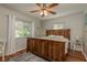 Bedroom featuring a rustic wooden bed, a ceiling fan, and a bright window with white curtains at 1253 Union St, Clearwater, FL 33755