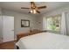 Bedroom featuring a wooden bed, a ceiling fan, and a bright window with white curtains at 1253 Union St, Clearwater, FL 33755