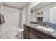 Well-lit bathroom with granite vanity top, integrated sink, and shower with white tile surround at 12775 Maple Bonsai Dr, Riverview, FL 33579