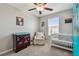 A cozy bedroom features neutral walls, a ceiling fan and a crib at 12775 Maple Bonsai Dr, Riverview, FL 33579