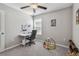 A cozy bedroom features neutral walls, ceiling fan, and a comfortable workspace at 12775 Maple Bonsai Dr, Riverview, FL 33579