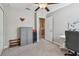 A cozy bedroom features neutral walls, ceiling fan, and closet leading to the laundry room at 12775 Maple Bonsai Dr, Riverview, FL 33579