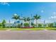 Community clubhouse featuring a symmetrical design, complemented by lush landscaping and vibrant palm trees on a sunny day at 12775 Maple Bonsai Dr, Riverview, FL 33579