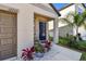 Charming front entrance with a blue door, complemented by potted plants and decorative rocks at 12775 Maple Bonsai Dr, Riverview, FL 33579