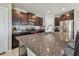 Spacious kitchen with granite countertops, stainless steel appliances, and dark wood cabinetry at 12775 Maple Bonsai Dr, Riverview, FL 33579