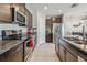 Well-equipped kitchen with granite countertops, stainless steel appliances, and stylish dark wood cabinets at 12775 Maple Bonsai Dr, Riverview, FL 33579