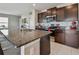 Open kitchen with granite counters, dark cabinets and stainless steel appliances at 12775 Maple Bonsai Dr, Riverview, FL 33579