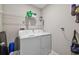Well-lit laundry room with modern washer and dryer, shelving for supplies, and cleaning equipment at 12775 Maple Bonsai Dr, Riverview, FL 33579