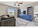 Cozy living space featuring a large window and blue media cabinet, bathed in natural light at 12775 Maple Bonsai Dr, Riverview, FL 33579