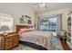 Bright bedroom with a queen-size bed, ceiling fan, and sliding doors to the patio at 1285 Salt Lake Dr, Tarpon Springs, FL 34689