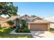 Charming home with a manicured lawn, palm trees, and a light-blue front door at 1285 Salt Lake Dr, Tarpon Springs, FL 34689