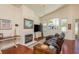 Cozy living room with a fireplace, leather sectional sofa, and a large window overlooking the backyard at 1285 Salt Lake Dr, Tarpon Springs, FL 34689