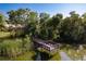 A wooden dock extends into a tranquil body of water, surrounded by lush greenery at 1285 Salt Lake Dr, Tarpon Springs, FL 34689