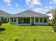 An overview of a spacious backyard and patio featuring green grass at 15329 Renaissance Ave, Odessa, FL 33556