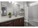 Bright bathroom with dual vanity, tub-shower combo, and decorative shelving at 15329 Renaissance Ave, Odessa, FL 33556