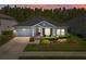 Charming single-story home with a well-manicured lawn and inviting front porch at dusk at 15329 Renaissance Ave, Odessa, FL 33556