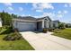 Charming single-story home with a well-manicured lawn and attached garage on a sunny day at 15329 Renaissance Ave, Odessa, FL 33556