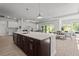 Open concept kitchen with dark cabinets, a large island, and seamless flow into the dining area at 15329 Renaissance Ave, Odessa, FL 33556