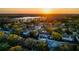 Stunning aerial view of the neighborhood at sunset, showcasing the lake and lush green trees surrounding the homes at 16819 Stanza Ct, Tampa, FL 33624