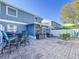 Back patio with screened-in porch and outdoor seating areas including tables and chairs with brick paved surface at 16819 Stanza Ct, Tampa, FL 33624