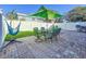 Spacious backyard with green umbrella, table, chairs, hammock and white fence, great for outdoor living at 16819 Stanza Ct, Tampa, FL 33624