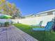 Fenced backyard with brick patio, artificial turf, outdoor furniture, and lounge chairs at 16819 Stanza Ct, Tampa, FL 33624